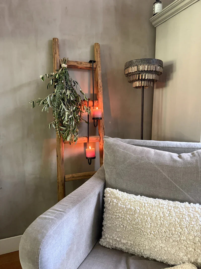 Landelijke houten ladder met hangend groen en kaarsen, naast grijze bank en lamp, My Sober Home