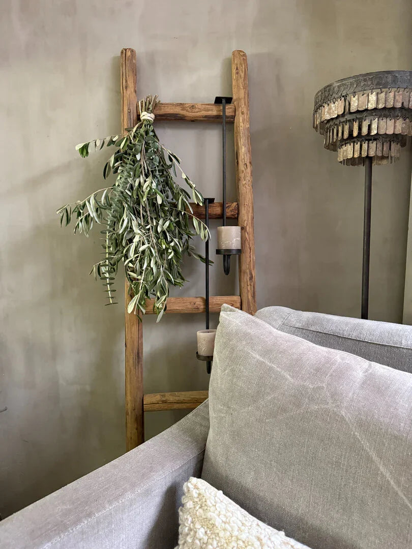 Houten decoratieladder met groene tak en landelijke accessoires in sober interieur