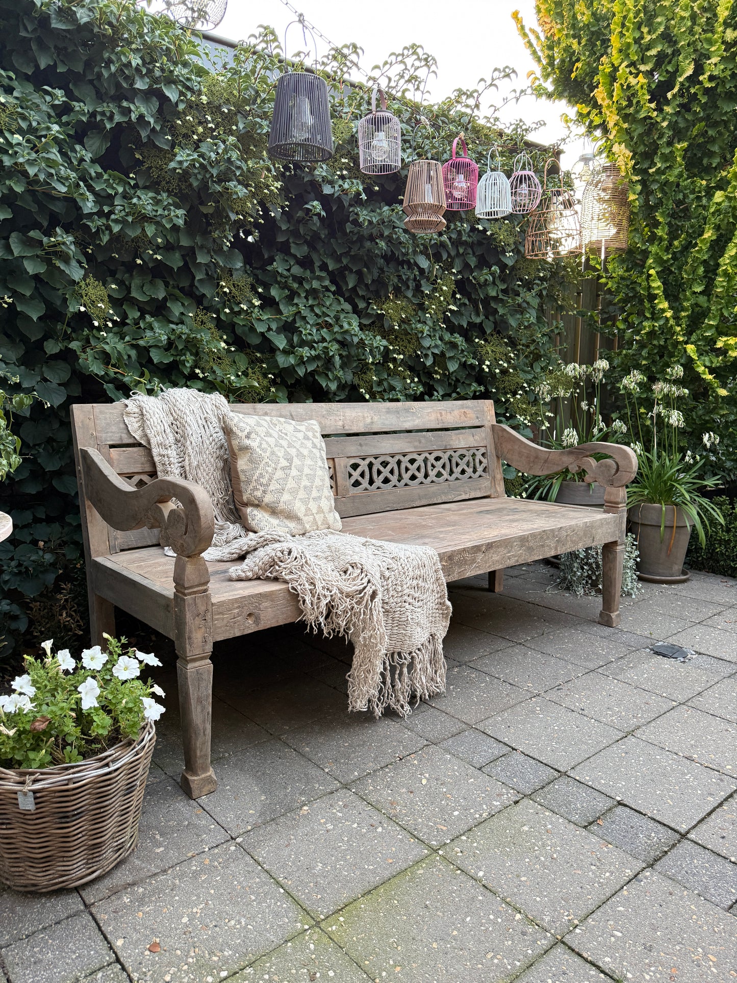 Oude stationsbank van hout met sierlijke armleuningen