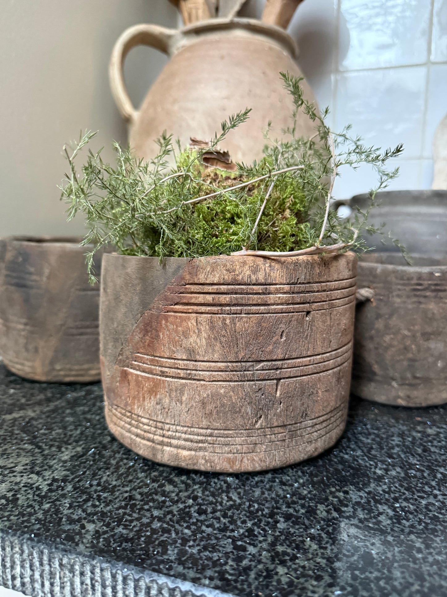 Authentiek houten potje met groene mosdecoratie, sfeervolle landelijke woonaccessoire