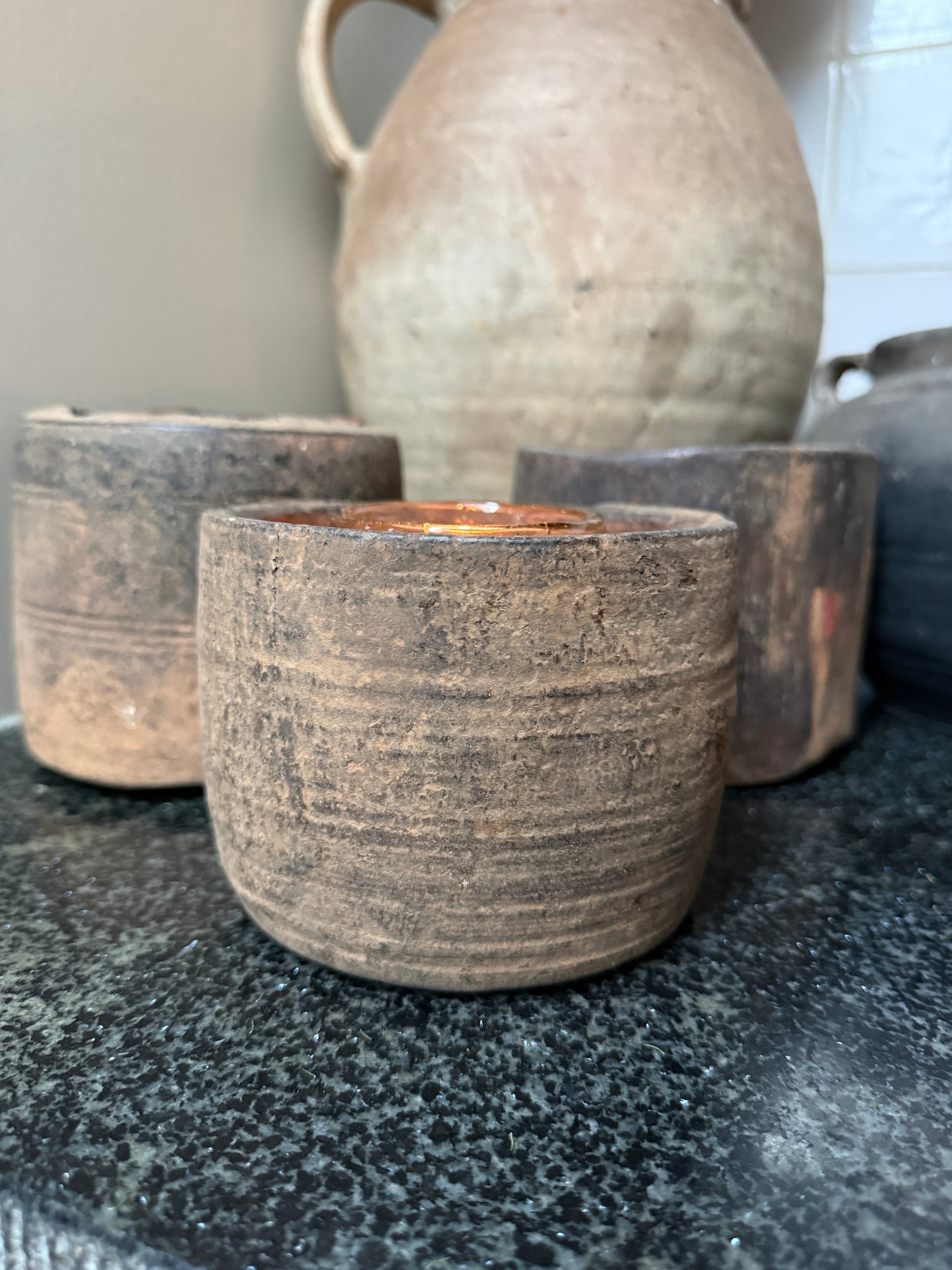 Handgemaakte sobere houten kandelaars op zwarte natuursteen, landelijke stijl woonaccessoire