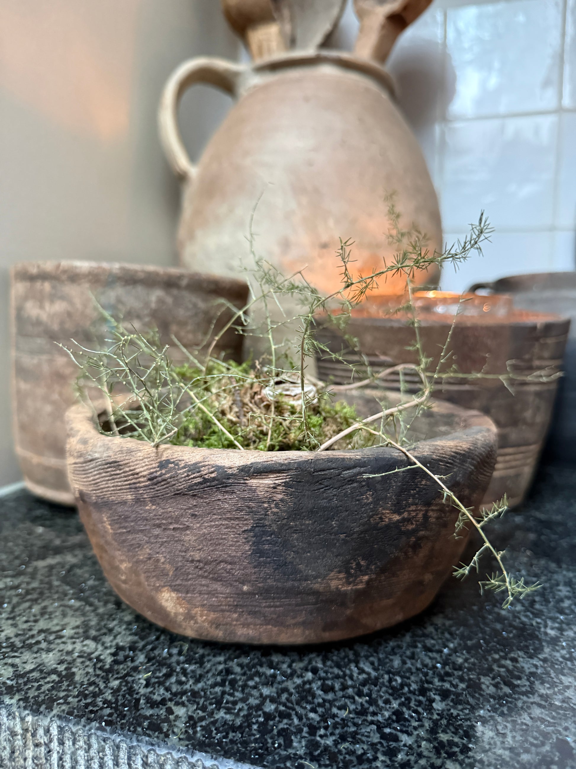 Handgemaakte houten schaal met mos en takjes, landelijke woonaccessoire op donkere stenen ondergrond, My Sober Home