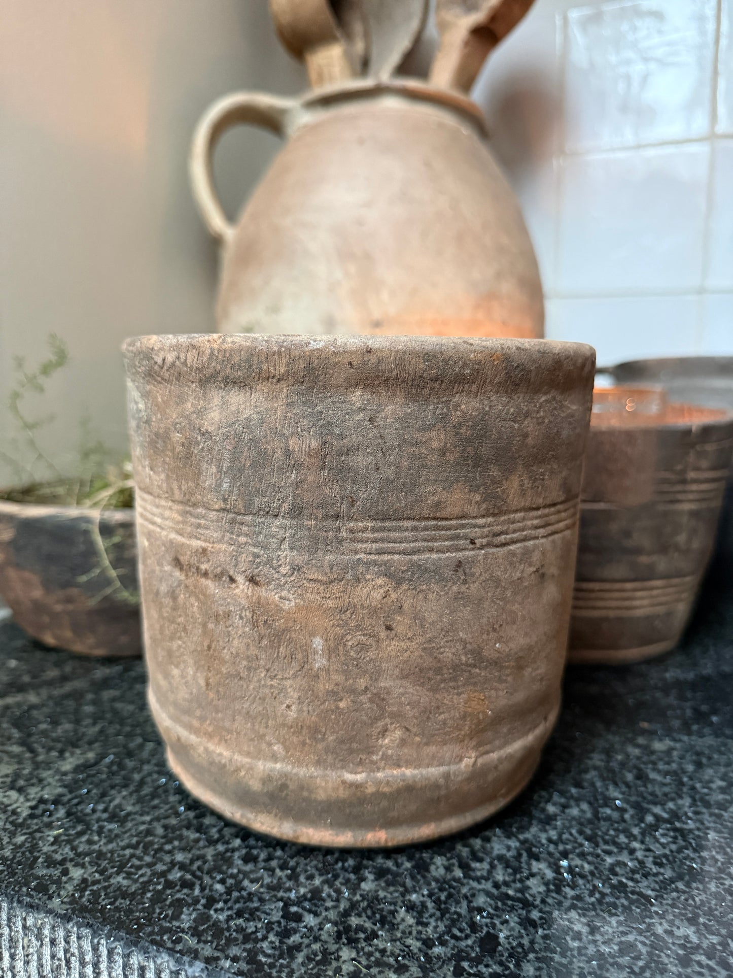 Oude handgemaakte aardewerken pot op zwart aanrecht, landelijk sober woonaccessoire India.