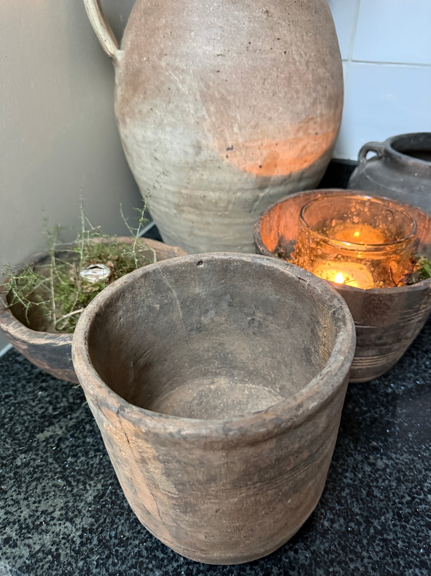 Handgemaakte, sobere aardewerken potten en windlicht op zwarte natuursteen, My Sober Home woonaccessoires.