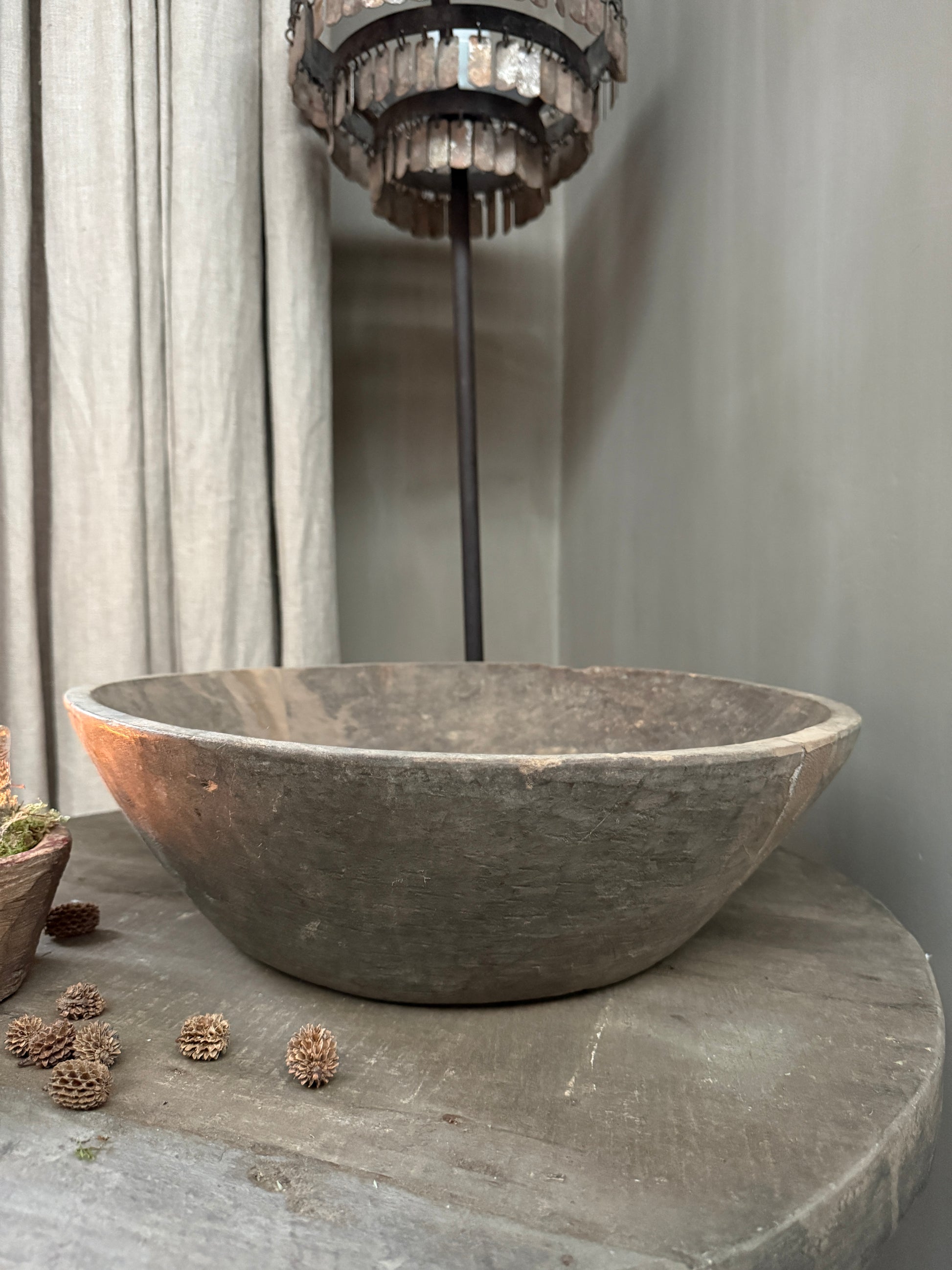 Authentieke handgemaakte houten schaal op tafel in sober landelijk interieur met lamp