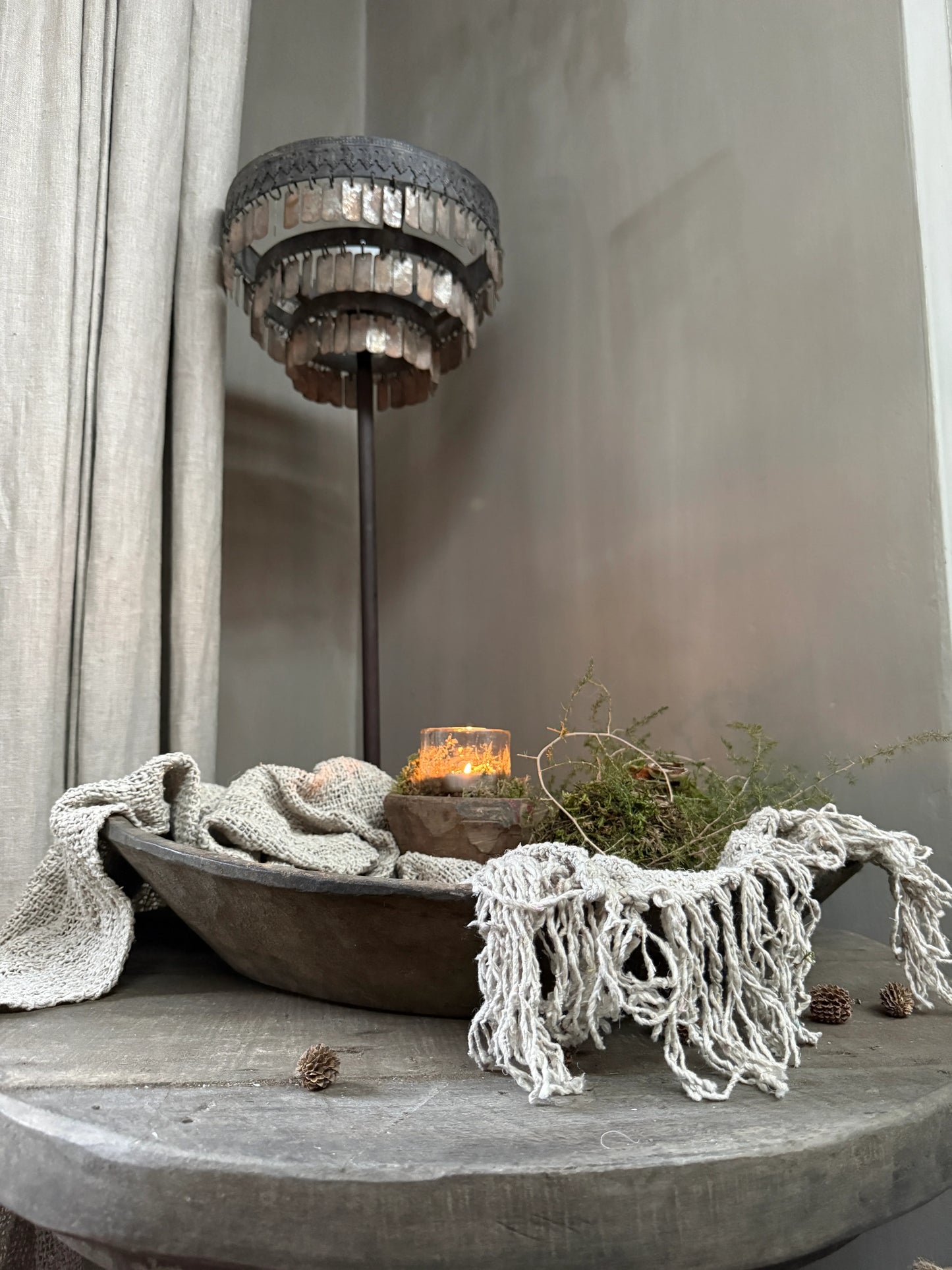 Sober handgemaakte woonaccessoires in landelijke stijl met kaars, hout en textiel op tafel