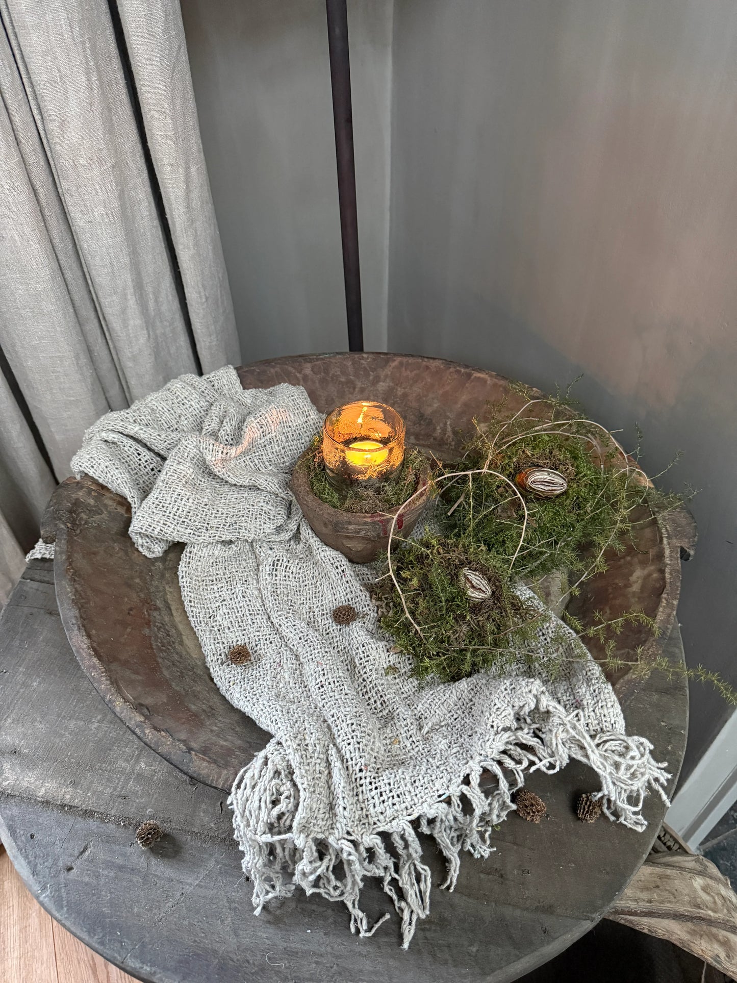 Sfeerbeeld met handgemaakte woonaccessoires, kaarsje en linnen doek op houten tafel