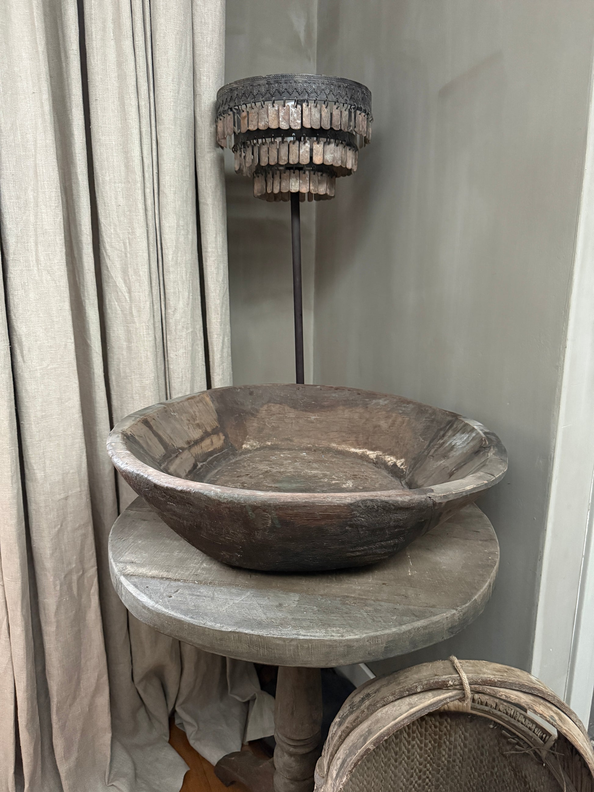 Authentieke handgemaakte houten schaal op ronde tafel, sobere landelijke woonaccessoires