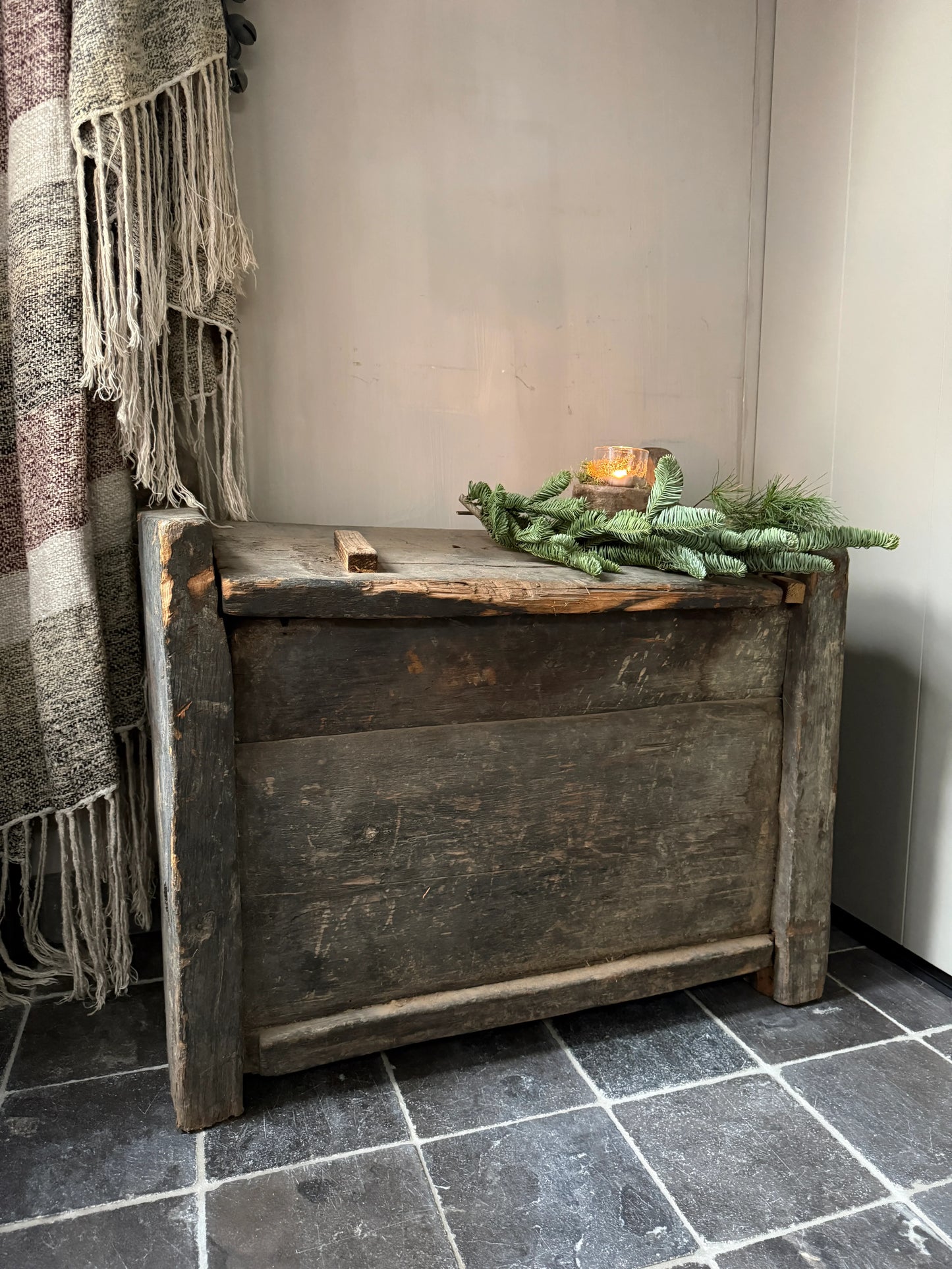 Antieke houten kist met groene tak en windlicht, landelijk sober interieur accessoire