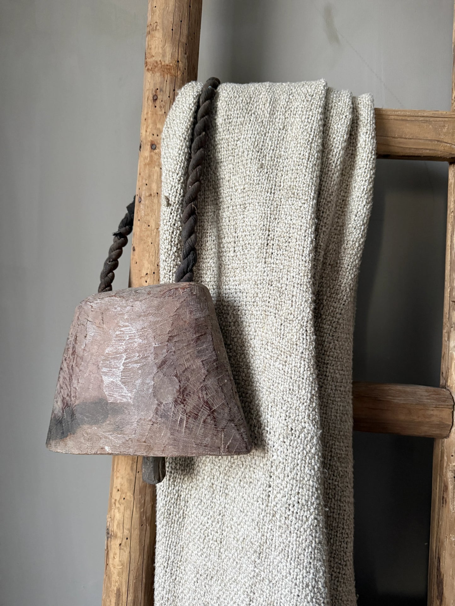 Landelijke houten ladder met beige plaid en handgemaakte houten bel, My Sober Home woonaccessoires