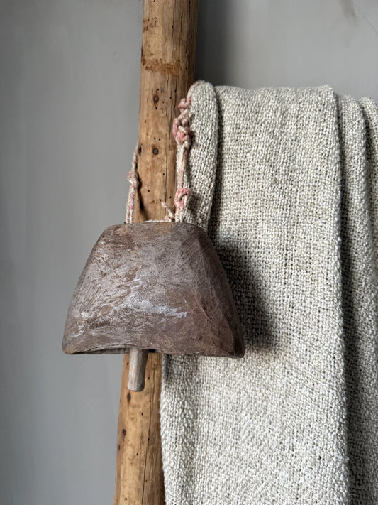 Handgemaakte houten bel met touw, op rustieke houten ladder en grof naturel kleed, My Sober Home