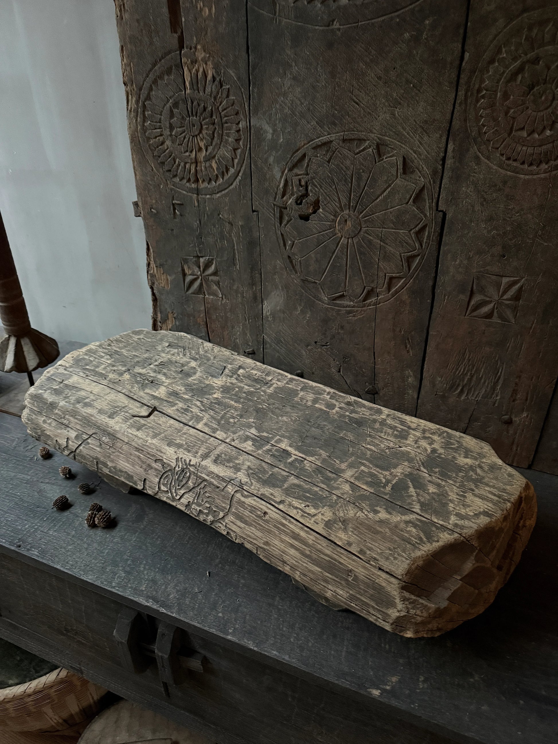 Authentiek handgemaakt houten object met gravures, sfeervol in sober landelijk interieur