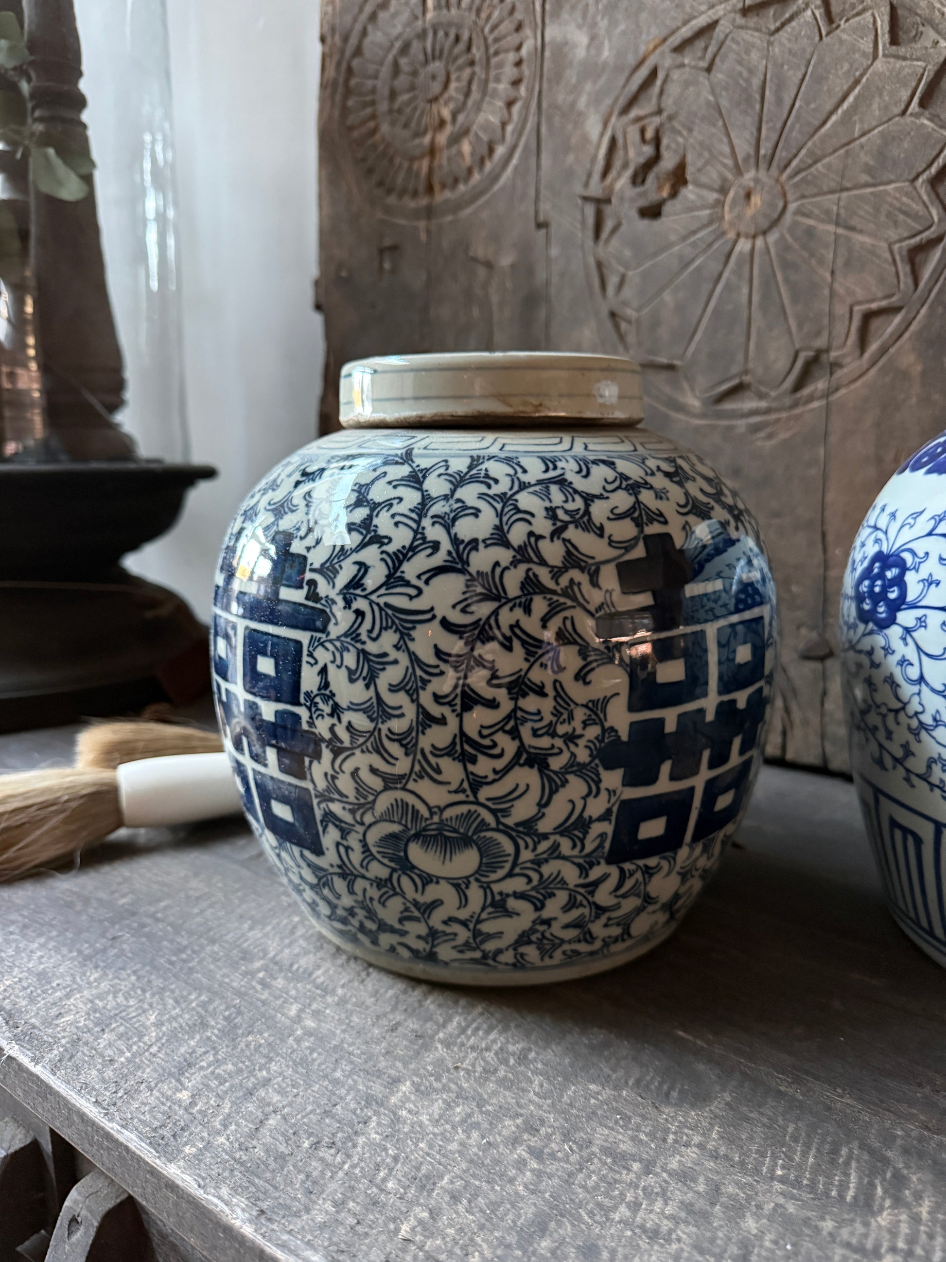Handgemaakte blauw-witte vaas met oosters patroon op houten tafel, landelijk sober interieur