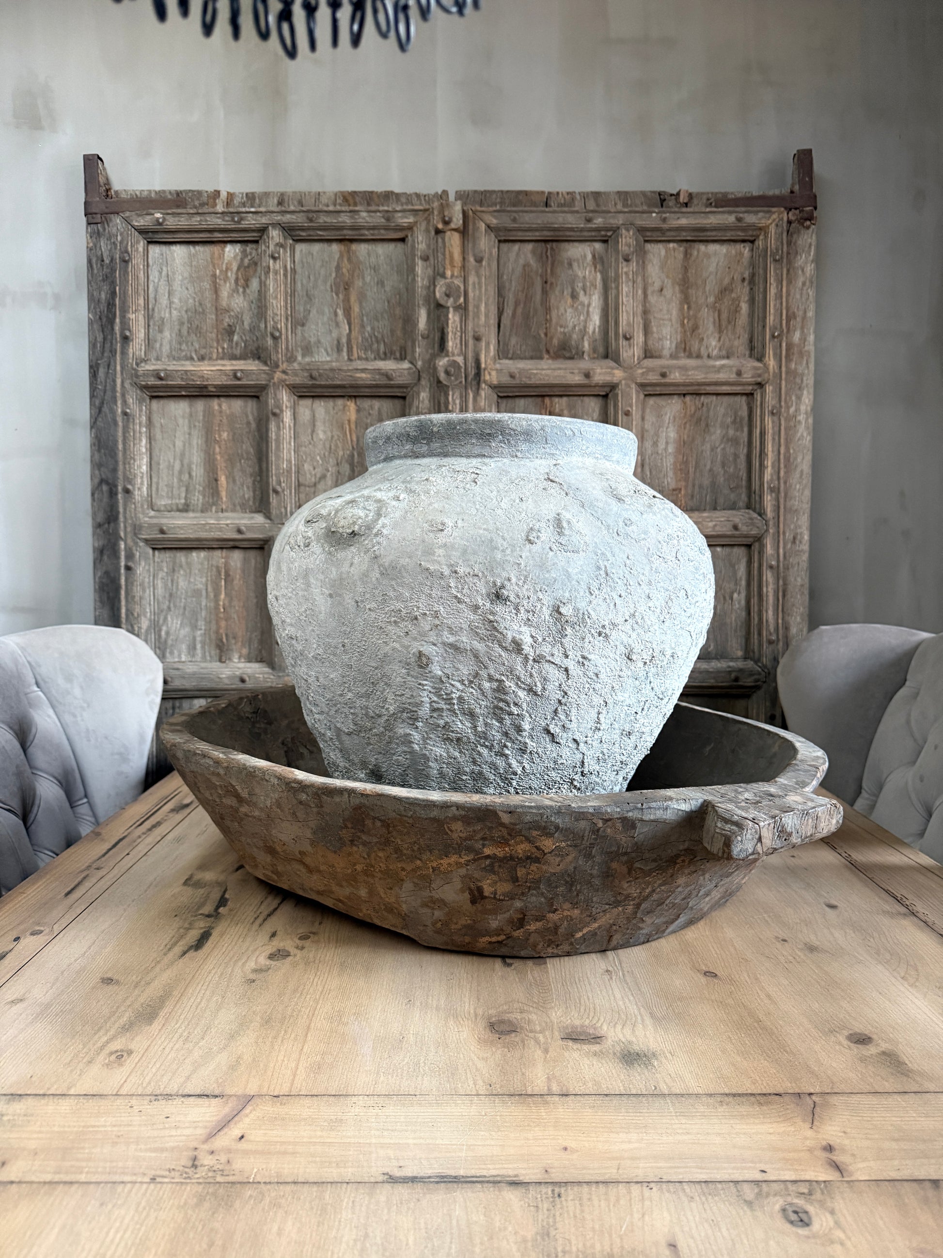 Authentieke, handgemaakte grijze pot en houten schaal op rustieke houten tafel, landelijk interieur