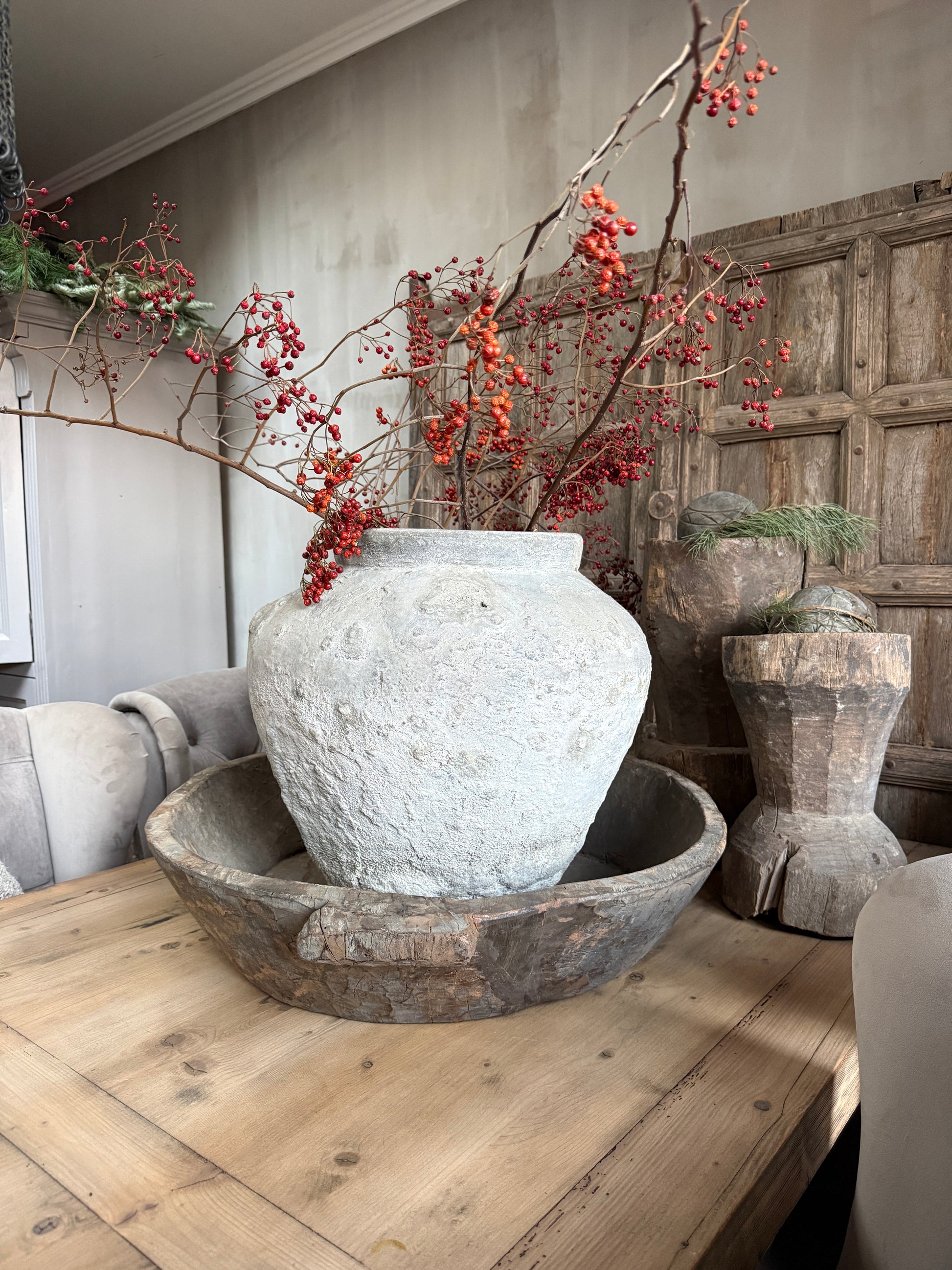 Oude stenen pot met rode bessentakken op houten schaal, landelijk interieur My Sober Home