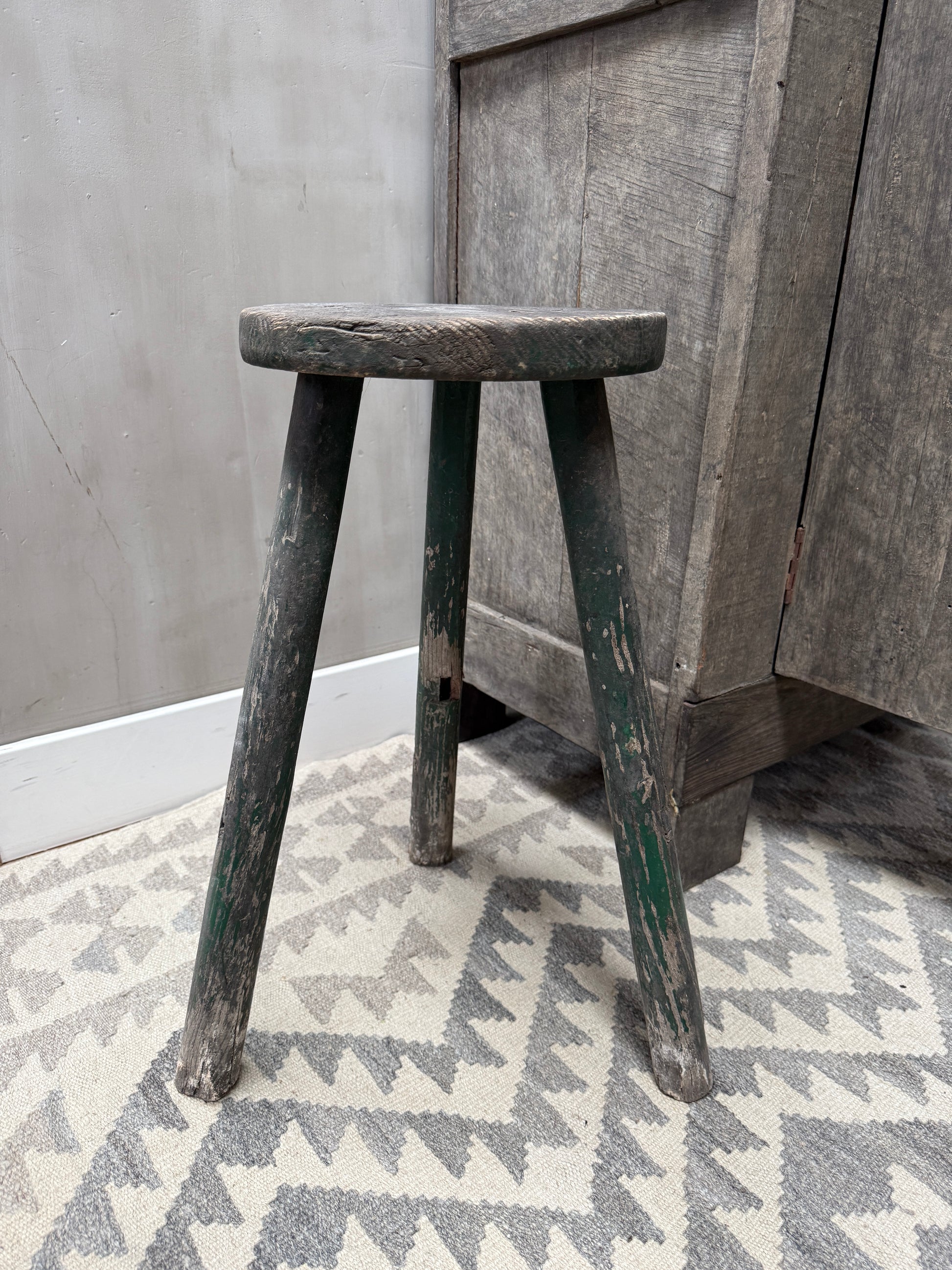 Authentieke handgemaakte houten kruk met verweerd groen, landelijk sober interieur