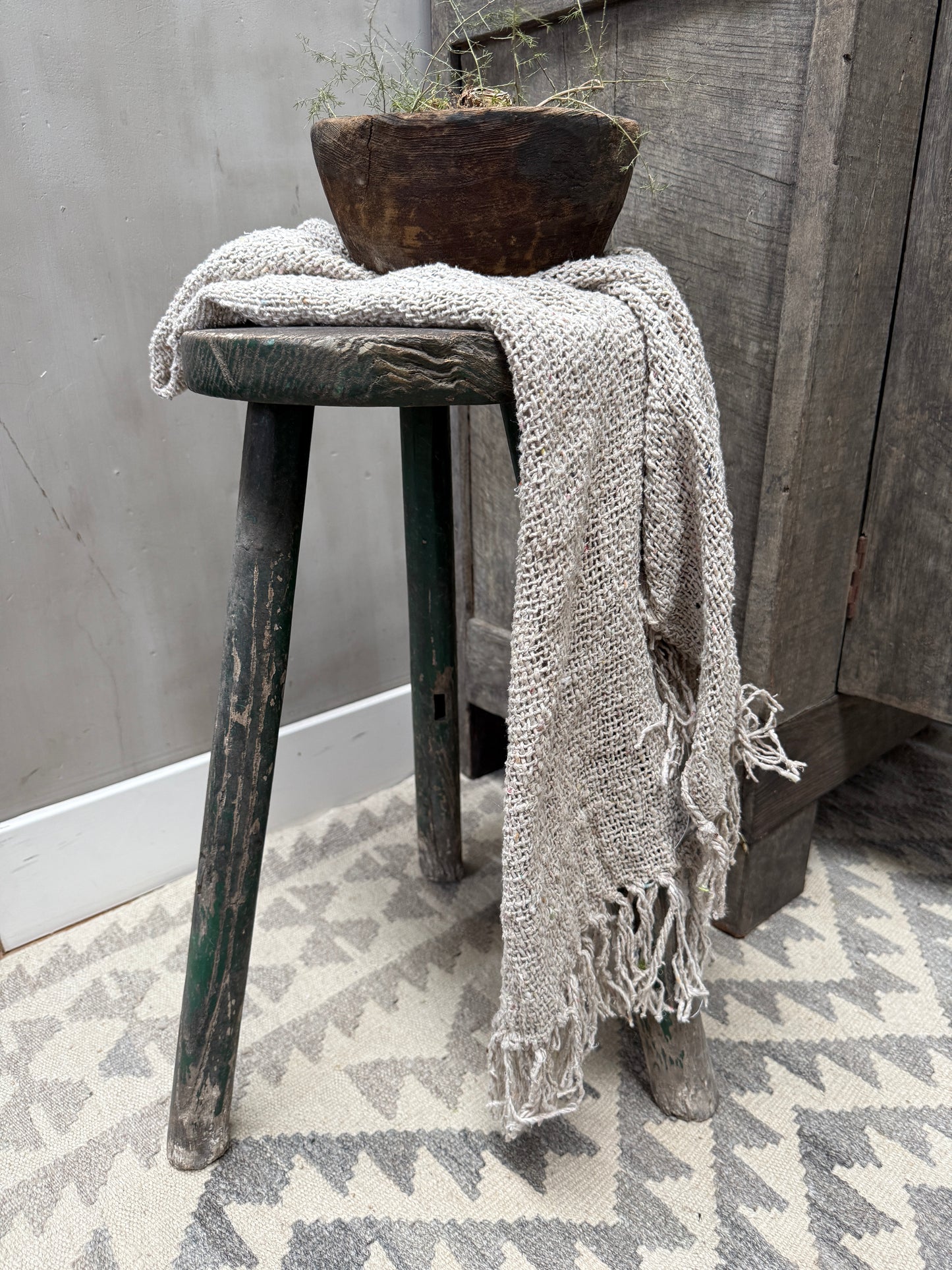 Oude houten kruk met handgemaakte linnen doek en vintage houten kom, landelijk sober interieur