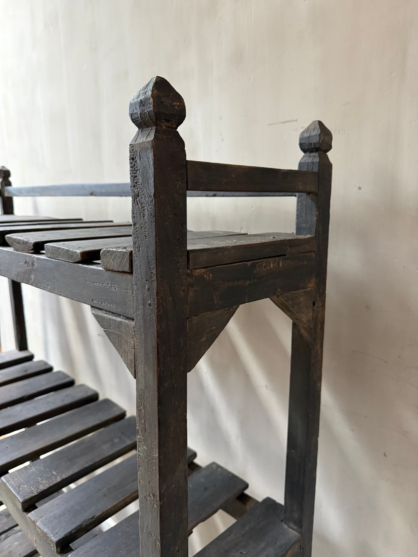 Handgemaakte, houten landelijke plankenkast met sober karakter tegen lichte muur