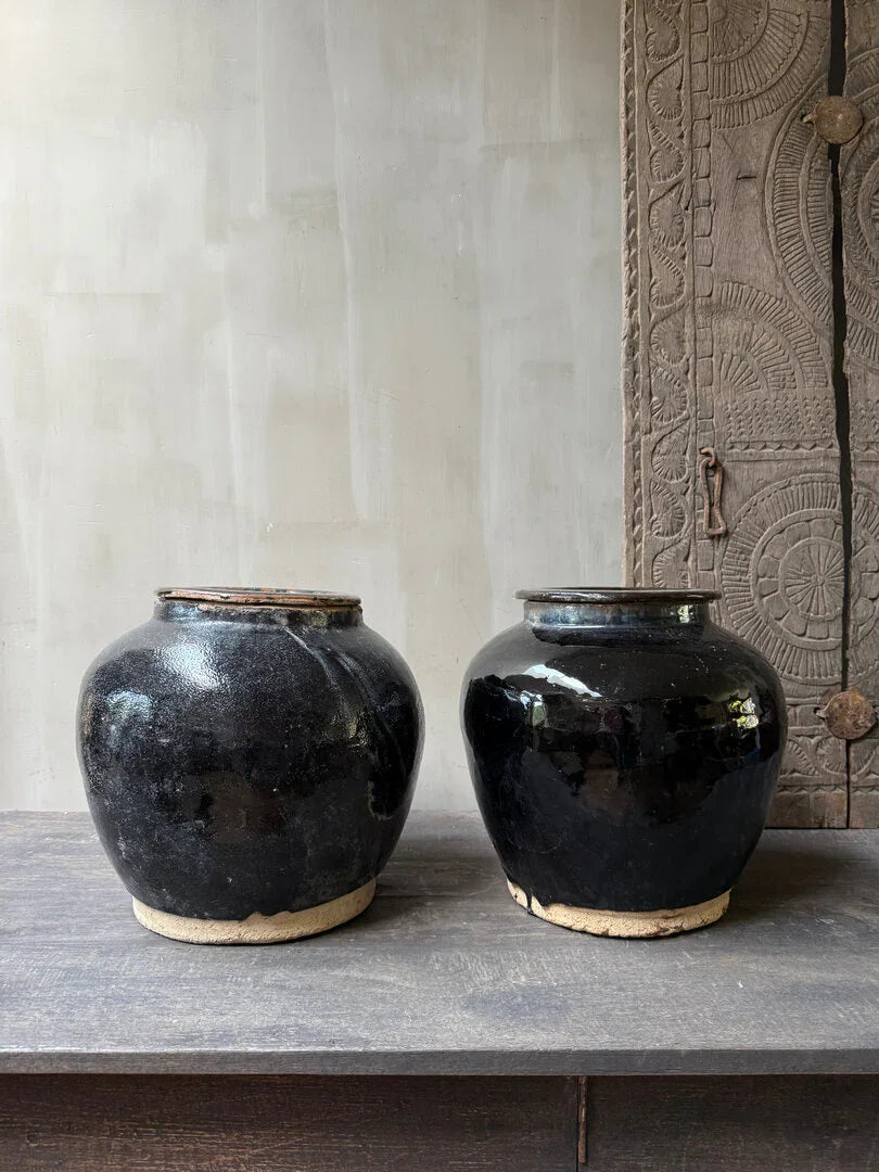 Twee zwarte, handgemaakte vintage kruiken op houten kast, landelijke woonaccessoires My Sober Home