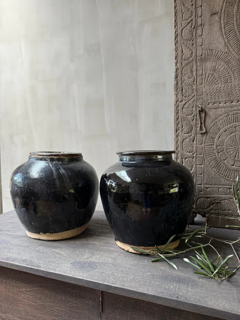 Twee handgemaakte zwarte aardewerken potten op houten tafel, landelijk sober interieur accessoire