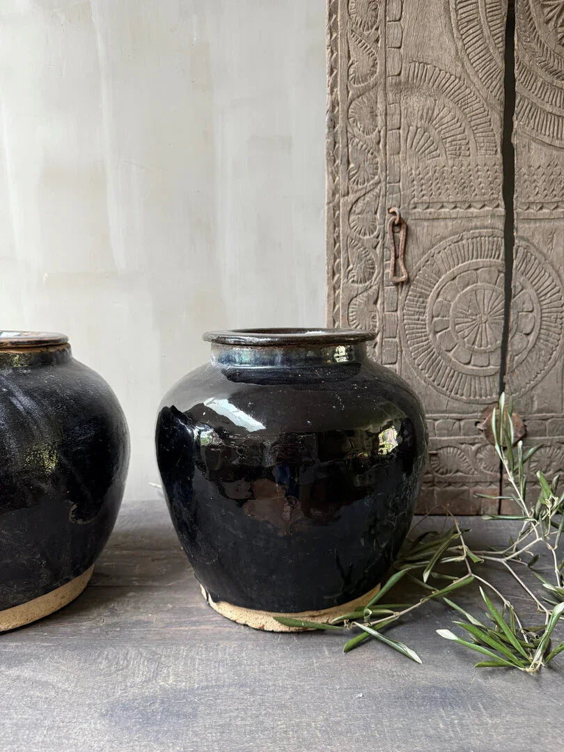 Authentieke zwarte keramische pot, handgemaakt, naast hout met reliëf, landelijke sfeer