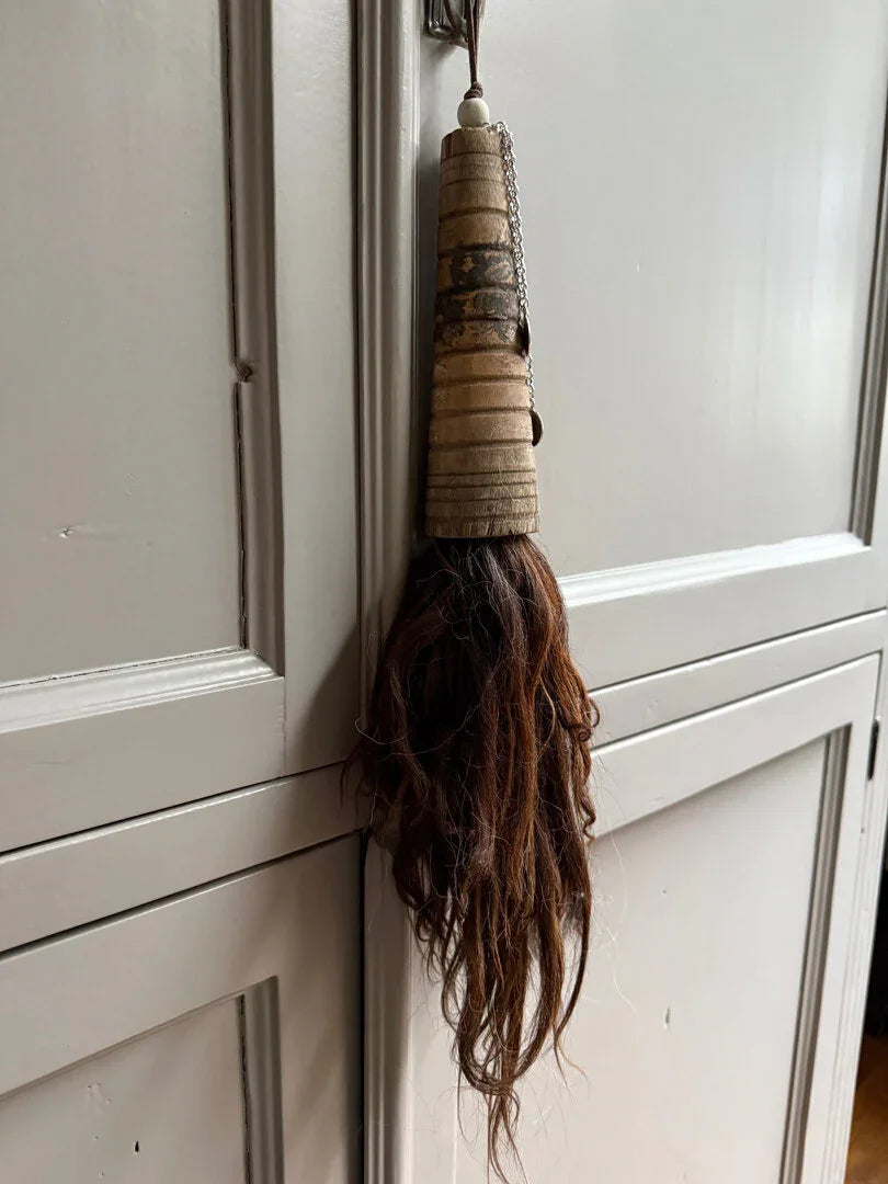 Handgemaakte landelijke hanger van hout en paardenhaar aan grijze kast, My Sober Home woonaccessoire