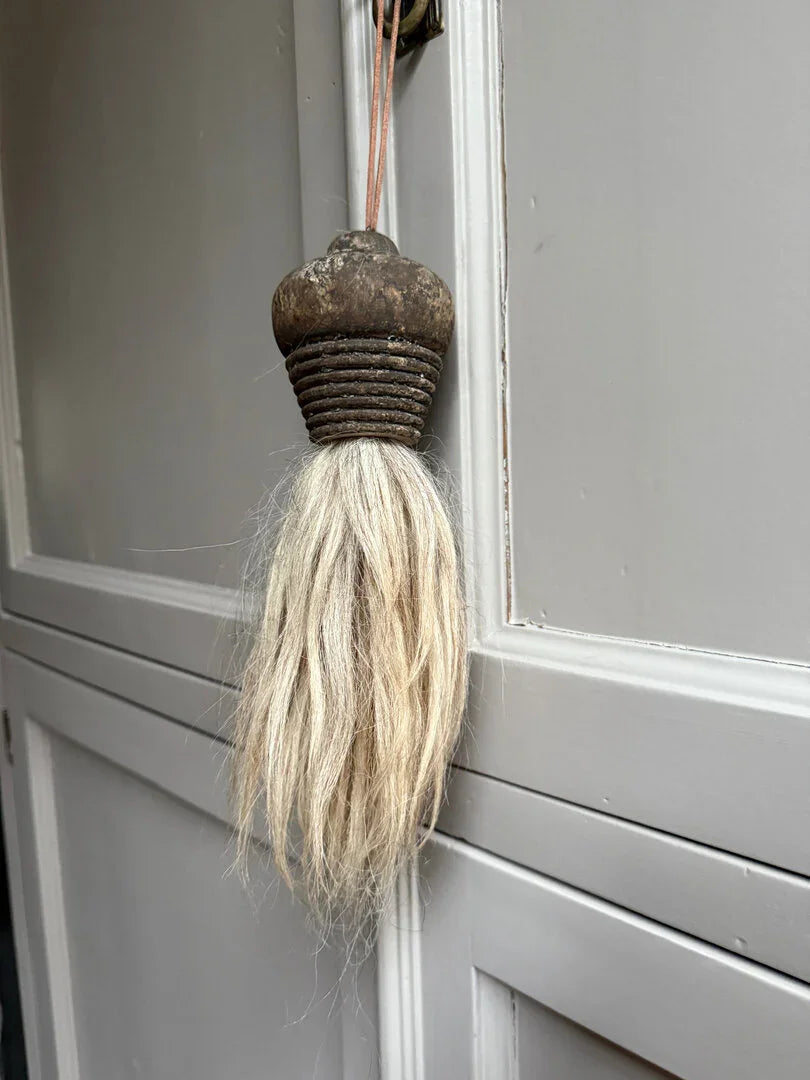 Authentieke, handgemaakte kwast van hout en wol aan landelijke kastdeur, sober interieur
