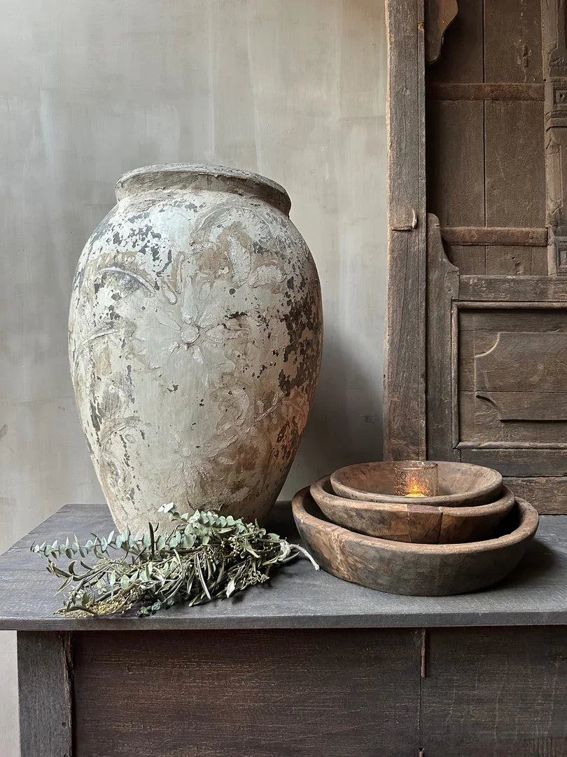 Authentieke, handgemaakte stenen vaas en houten schalen op landelijke kast, My Sober Home woonaccessoires.