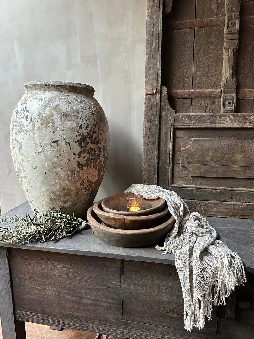 Authentieke landelijke vaas, houten schalen en linnen doek op sobere houten tafel