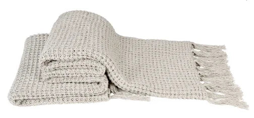 Lichtgrijze, handgemaakte plaid met franjes, ideaal voor een landelijk en sober interieur.