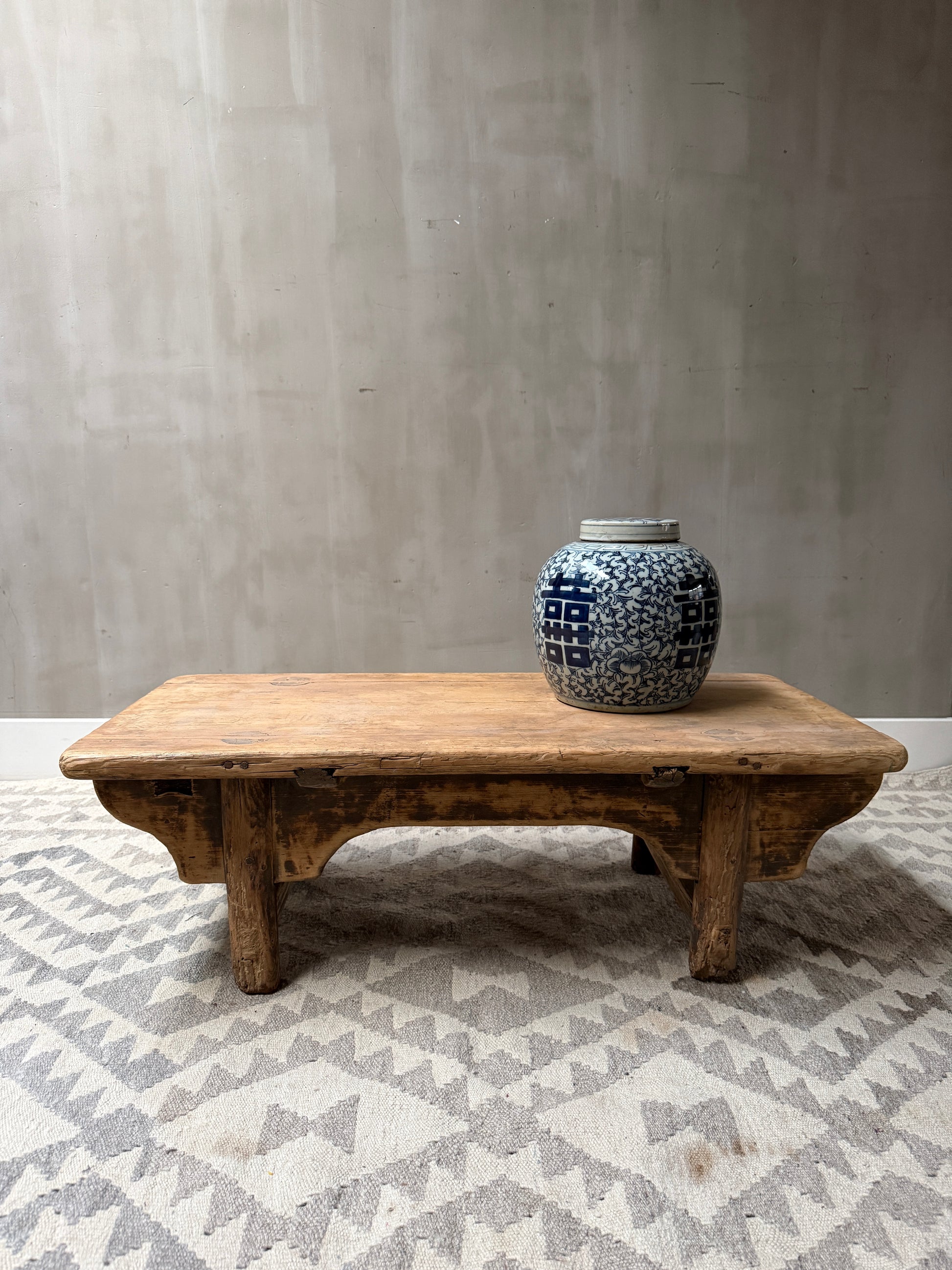 Handgemaakte houten salontafel met blauwe keramische pot, landelijk en sober interieur