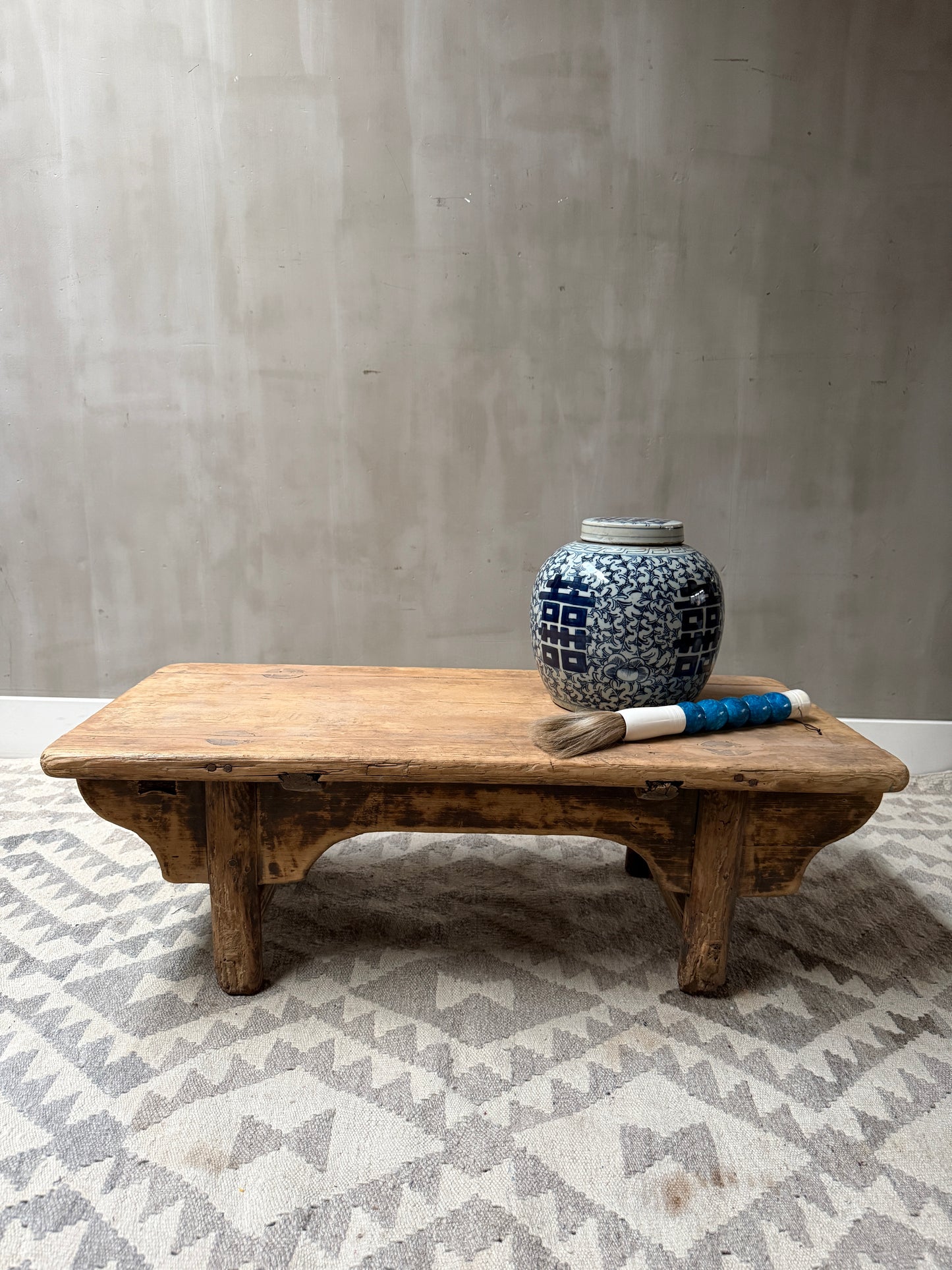 Authentieke lage houten tafel met blauw-witte pot en borstel, landelijk interieurdecor My Sober Home
