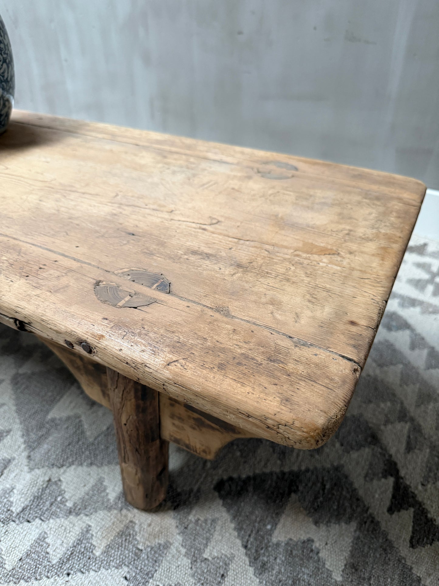 Authentieke handgemaakte houten salontafel op vloerkleed, landelijk interieur