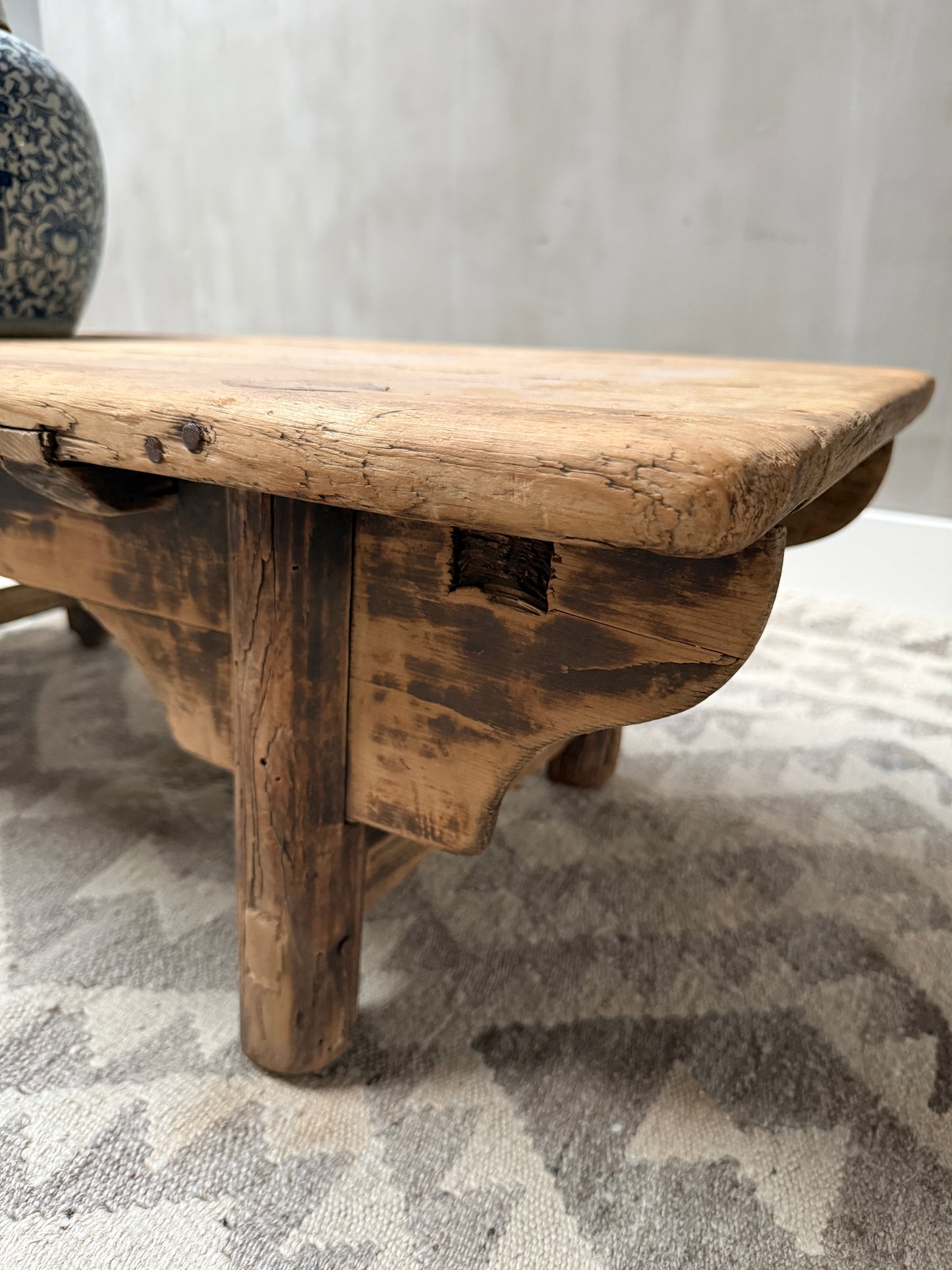 Authentieke handgemaakte houten bijzettafel, landelijk en sober, op vintage vloerkleed