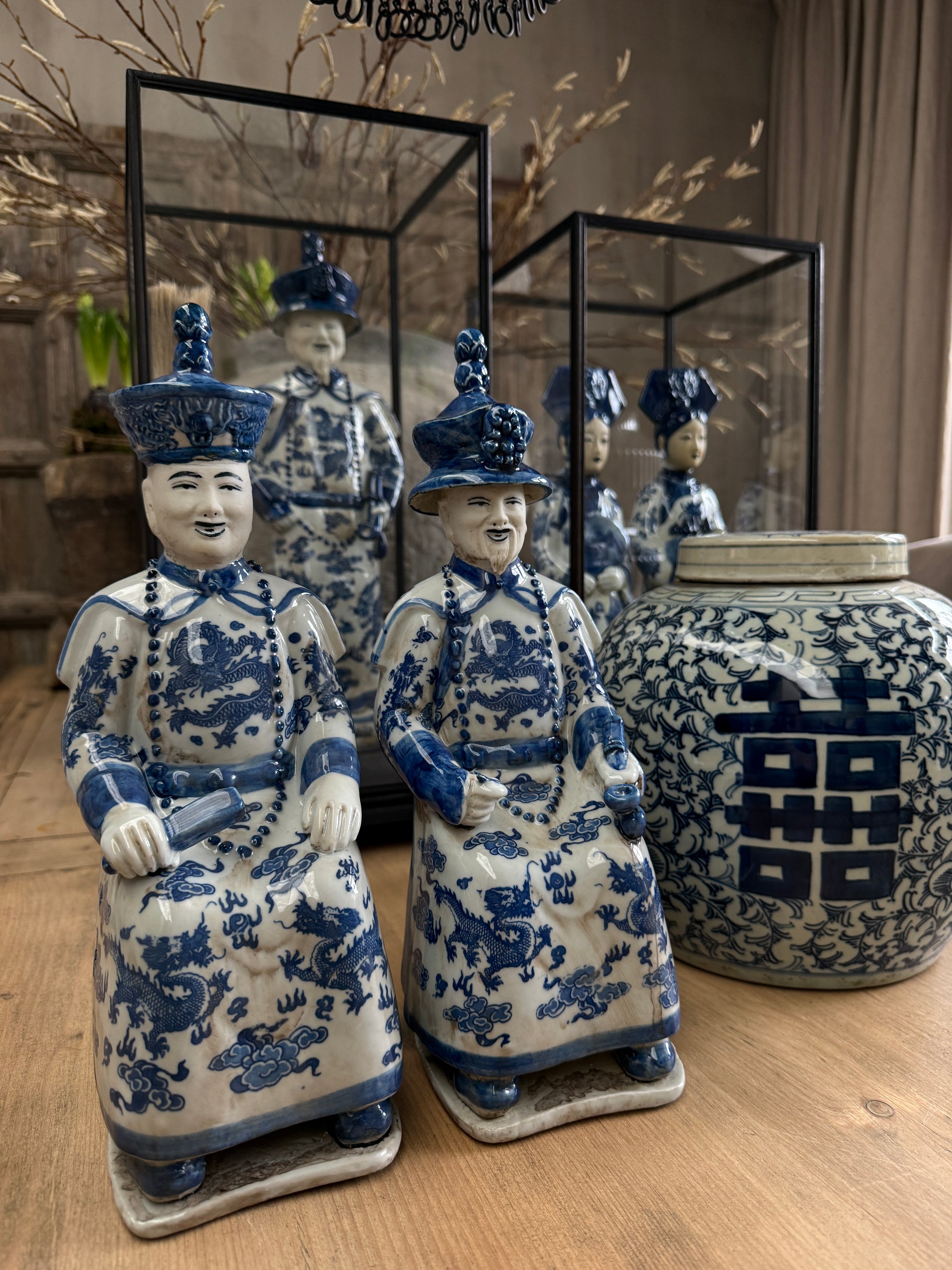 Blauw-witte keizerbeeldjes en handgemaakte vaas op houten tafel, landelijk en sober interieur