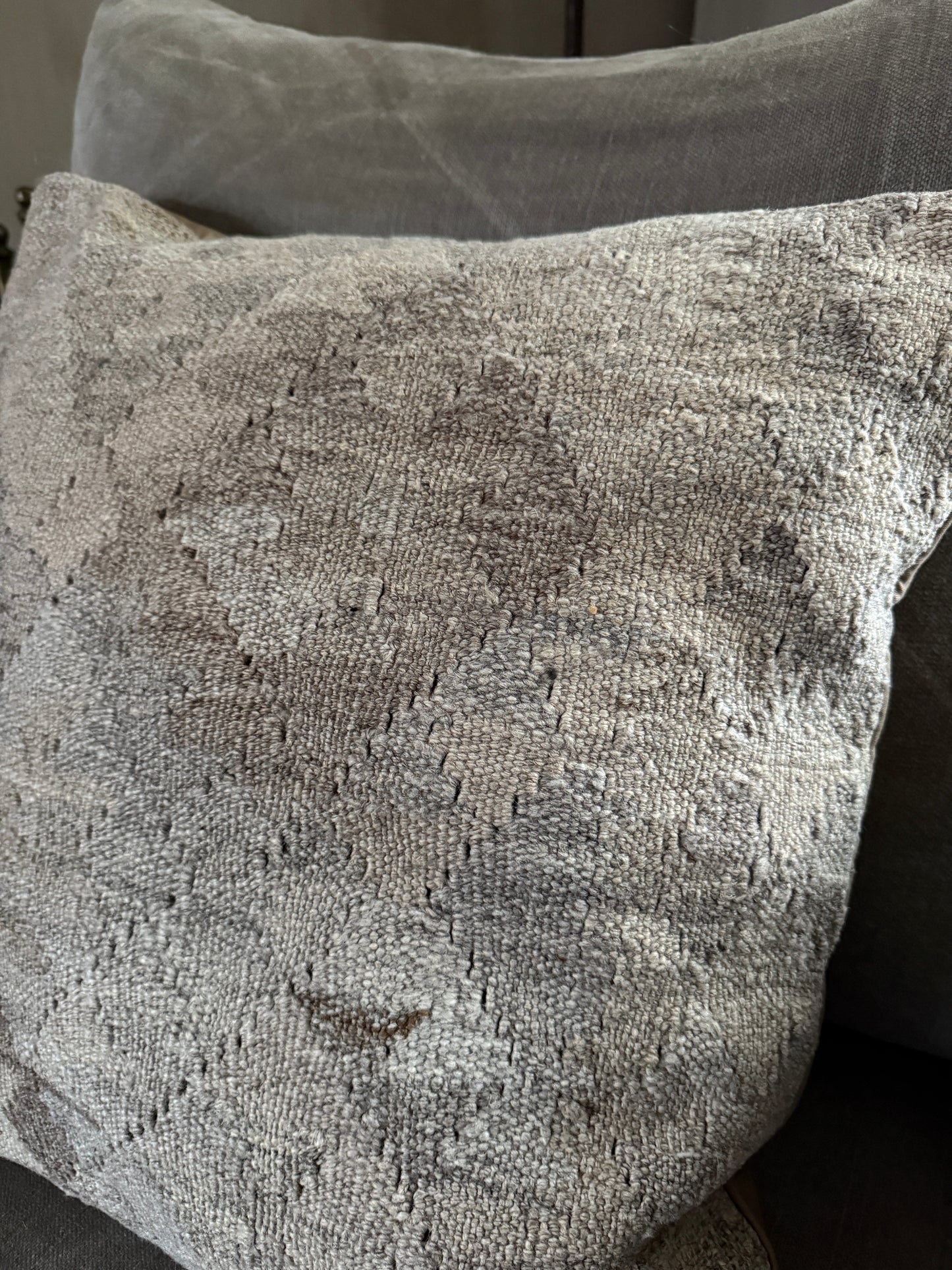 Handgemaakt kelim kussen in grijstinten op een landelijke, sobere bank bij My Sober Home