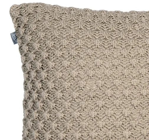 Close-up beige gebreid kussen met structuur voor een landelijk, sober interieur bij My Sober Home