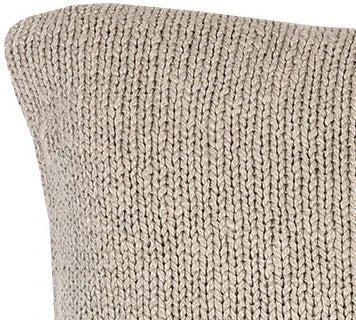 Close-up van een handgemaakt beige gebreid kussen, landelijk en sober woonaccessoire.