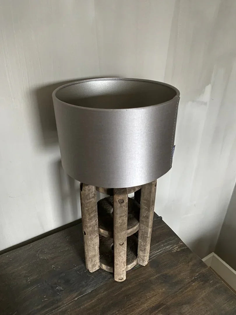 Handgemaakte landelijke tafellamp met houten voet en grijze kap op donkere houten tafel