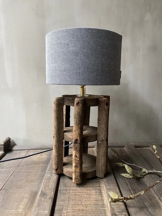 Handgemaakte landelijke tafellamp met grijze katoenen kap en houten voet, sober interieur