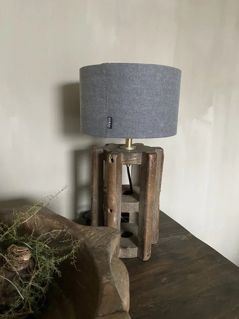 Handgemaakte houten tafellamp met grijze katoenen kap op rustieke tafel, landelijk interieur