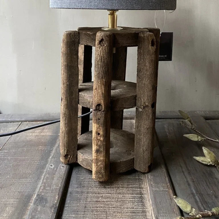 Handgemaakte lamp met robuuste houten basis en grijze katoenen kap, landelijk interieur