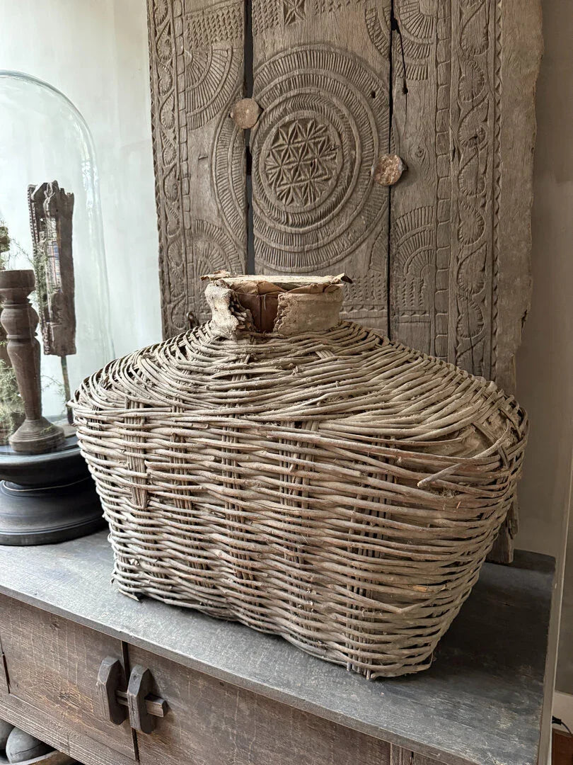 Authentieke handgemaakte leemmand XL van gevlochten riet op houten kast voor sober interieur