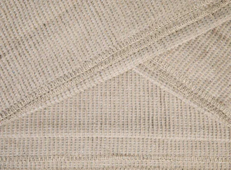 Close-up van beige handgemaakt woonaccessoire, geweven structuur, sober landelijk interieur