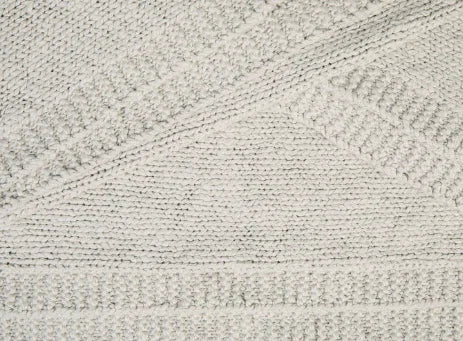 Close-up van een handgemaakt, grofgebreid beige woonaccessoire voor landelijk interieur