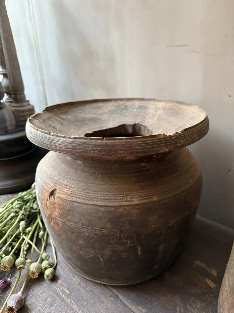 Authentieke Nepalese kruik van donker hout, handgemaakt, op houten tafel met gedroogde bloemen