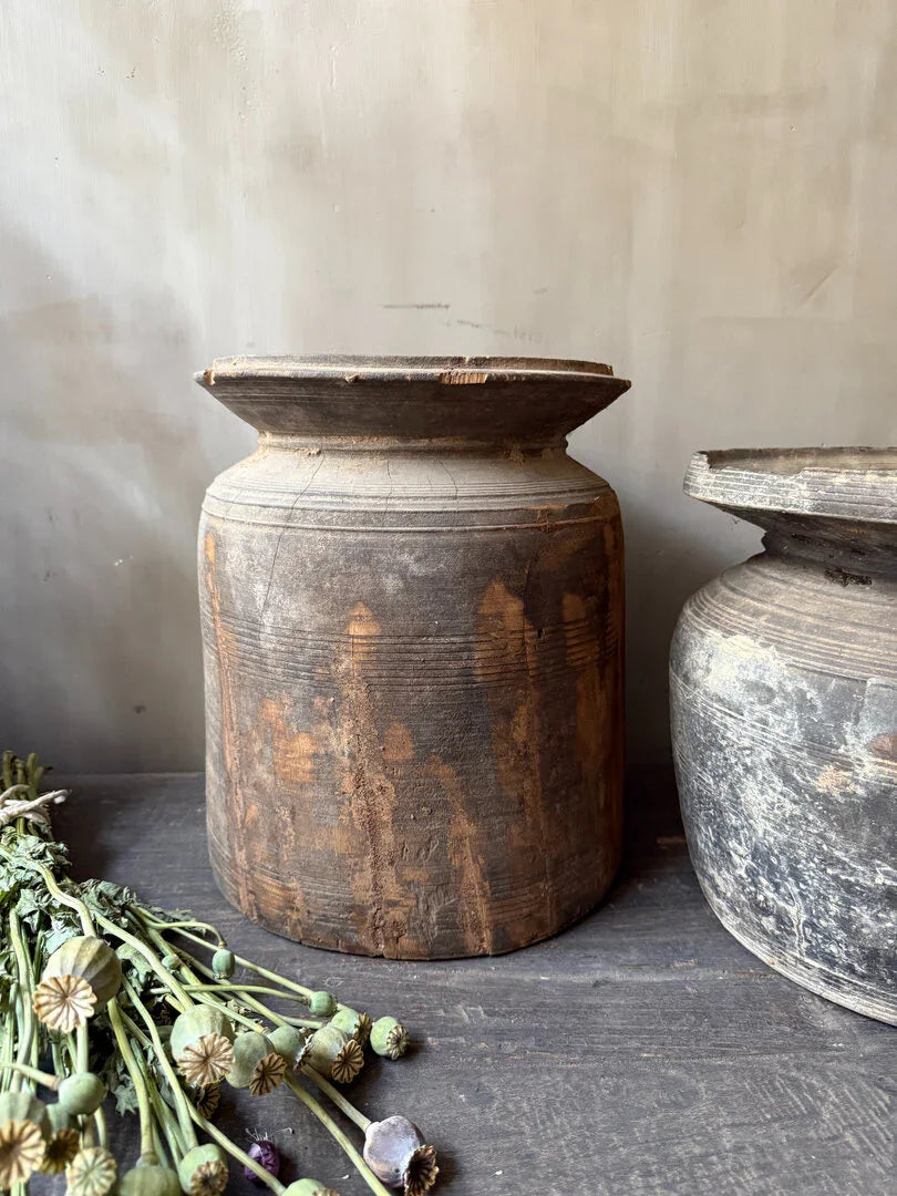 Authentieke Nepalese kruik van hout op een donkere tafel, landelijke sobere woondecoratie