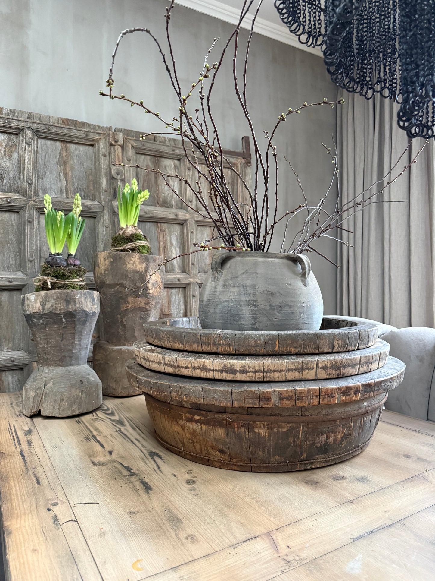 Authentieke houten olijfbakken en handgemaakte vaas op houten tafel, landelijk sober interieur