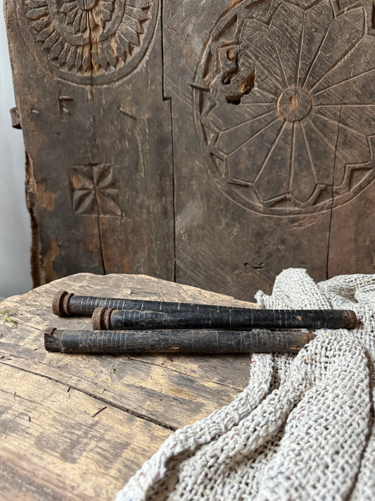 Drie antieke, handgemaakte houten staven op rustiek houten tafel, landelijke woonaccessoire