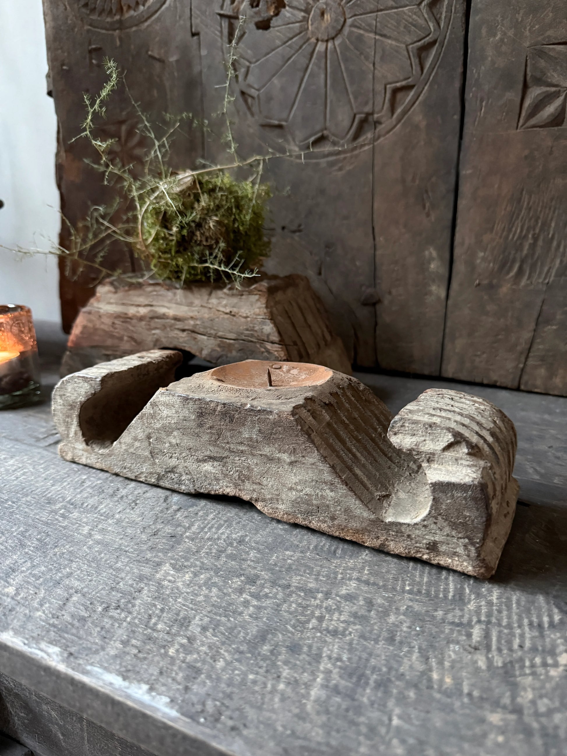 Authentieke houten ornament kandelaar op sober houten tafel, landelijke woonaccessoire
